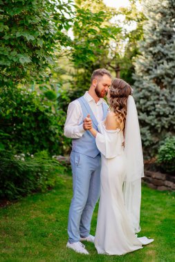 Yaz bahçesinde yürüyen yeni evliler. Parkta düğün fotoğrafı çekimi var..