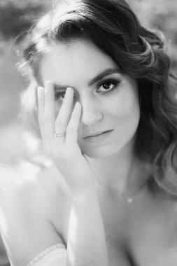 Yakın plan. Yüzünde eli olan güzel bir kadının siyah beyaz portresi..