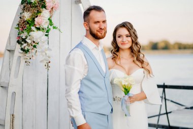 Rıhtımda suyun kenarında güzel bir düğün töreni. gelin ve damat.