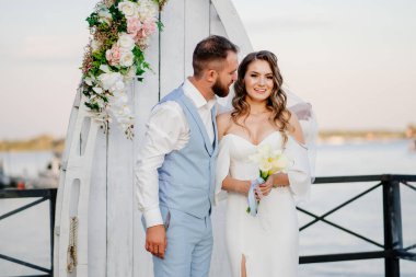 Rıhtımda suyun kenarında güzel bir düğün töreni. gelin ve damat.