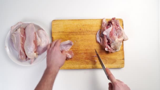 Mannelijke handen slager karkas van rauwe kip op een houten snijplank — Stockvideo