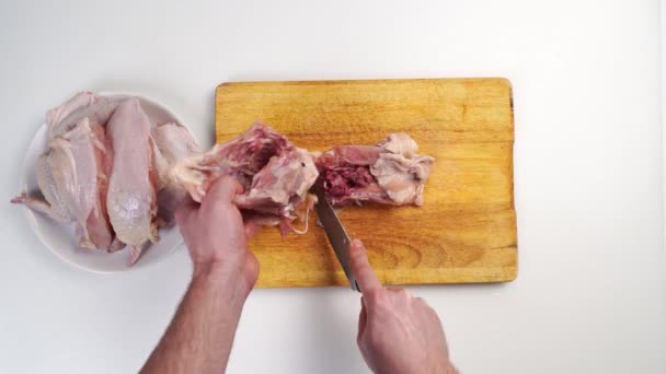 Mężczyzna ręce rzeźnik tusza z surowego kurczaka na drewnianej desce do krojenia — Wideo stockowe