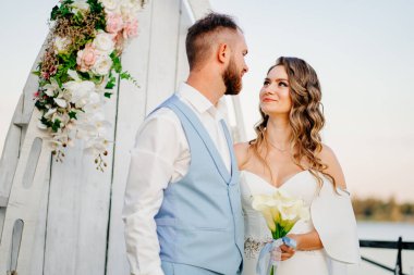 Rıhtımda suyun kenarında güzel bir düğün töreni. gelin ve damat.