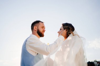 Güneş parlaması. Uzun bukleli, beyaz, zarif elbiseli gelin.