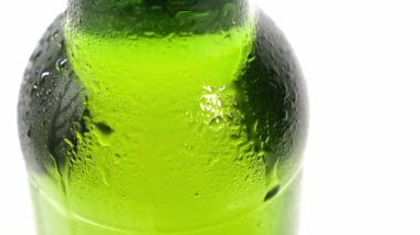 Kapat. Damlalar şişenin soğuk yeşil camından aşağı akar. yoğunlaştır