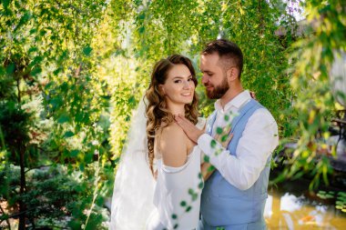 Mavi takım elbiseli damat ve söğüt rengi bukleli gelin.