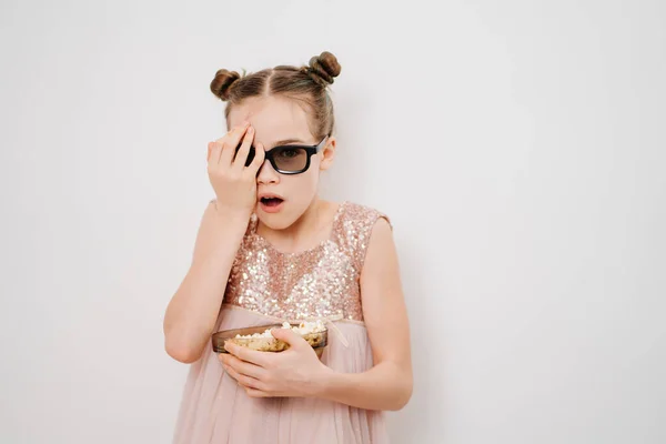 Adolescente chica con gafas para ver miedo películas en 3D con palomitas de maíz contra la pared blanca — Foto de Stock
