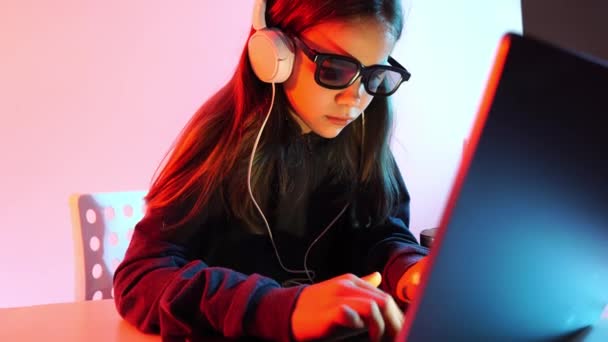 Lány sötét ruhában, fejhallgató és 3D-s szemüveg dolgozik éjszaka a számítógépen. — Stock videók