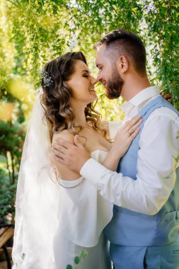 Mavi takım elbiseli damat ve söğüt rengi bukleli gelin.