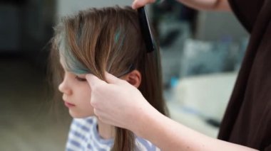 Saç kesimi. Anne saçlarını tarar ve ayırır..