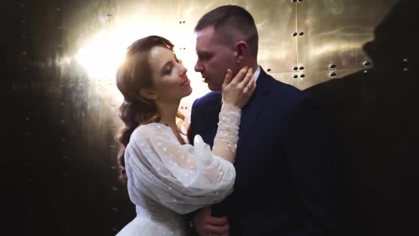 Küsst Braut und Bräutigam im Dunkeln im Lichtstrahl. — Stockvideo