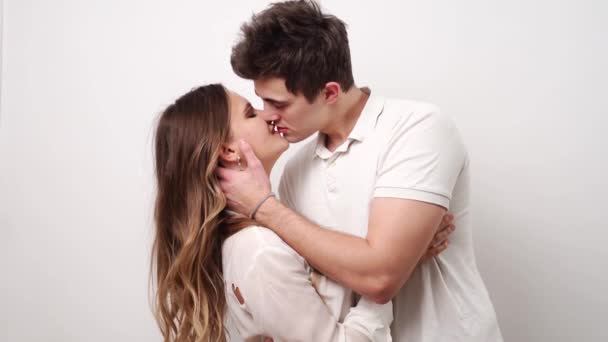 Szerelem, szenvedélyes és gyönyörű pár csókol a fehér falnak. — Stock videók