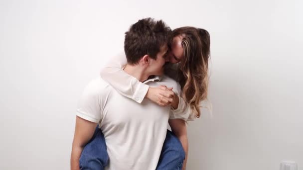 Amour, baisers couple passionnés et beaux, amusez-vous contre le mur blanc. — Video