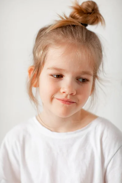 Portret van een verdrietig klein meisje in een wit T-shirt. — Stockfoto