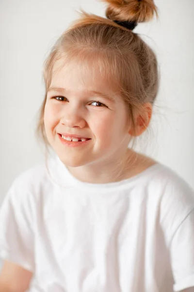 Portrait d'une petite fille joyeuse dans un T-shirt blanc. — Photo
