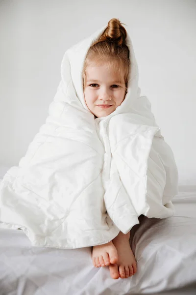 Kleines Mädchen unter einer Decke. Früh morgens in die Schule aufwachen — Stockfoto
