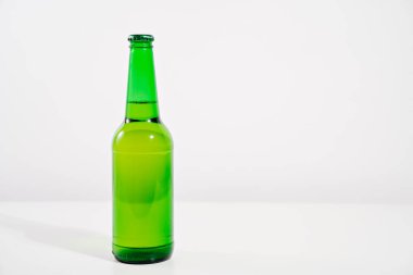 Beyaz arka planda yeşil cam şişe. yoğunlaştır