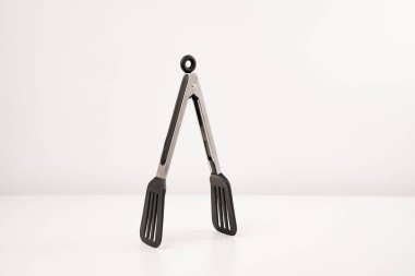 black Kitchen tongs on a white background. clipart