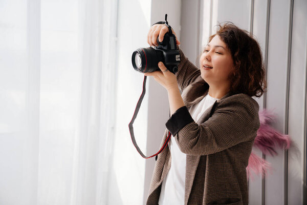 A brunette woman working photographer. photo shoot in a photo studio. backstage 