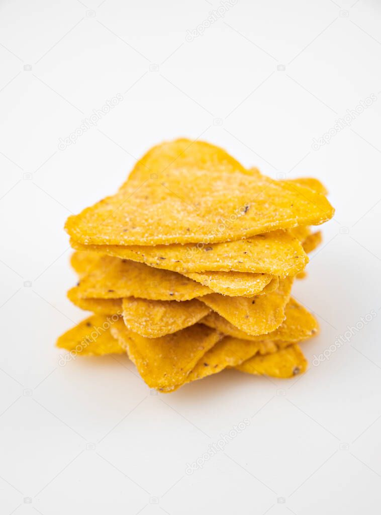 tower of Nachos on a white table. Mexican snack, corn tortilla chips.