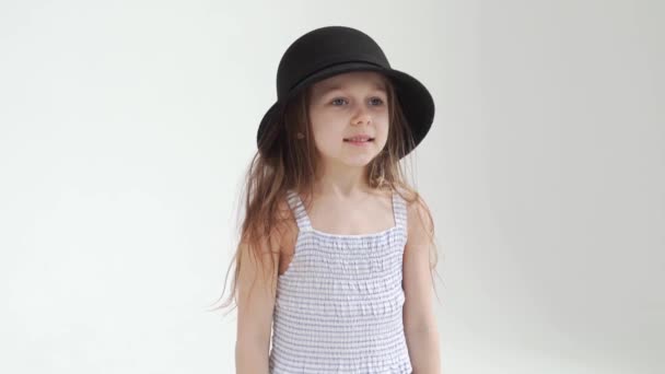 Cute little girl plays with a black hat. the child tries on my mothers clothes. — Stock Video