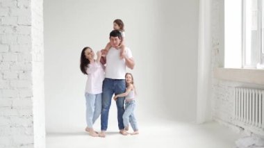 Beyaz bir fotoğraf stüdyosundaki fotoğraf çekiminde güzel, mutlu bir aile. sahne arkası.