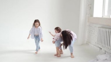 Beyaz bir fotoğraf stüdyosundaki fotoğraf çekiminde güzel, mutlu bir aile. sahne arkası.