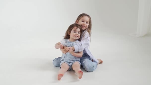 Oudere zus knuffelt jongere zus, en ze loopt weg. rusteloze kinderen. — Stockvideo