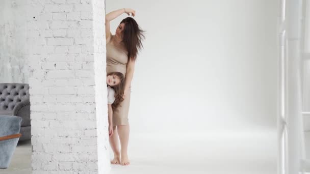 Mãe e filha posam em um estúdio de fotos branco. bastidores. — Vídeo de Stock