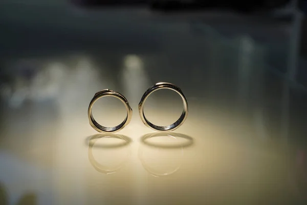 Dos anillos de oro de boda reflejados en la superficie espejada — Foto de Stock