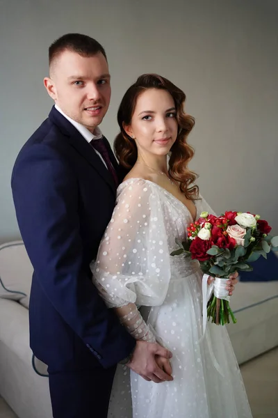 El novio con un ramo de flores para la novia en el día de la boda. — Foto de Stock