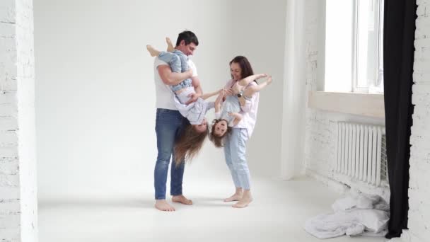 Bela família feliz em uma sessão de fotos em um estúdio de fotos branco. bastidores. — Vídeo de Stock