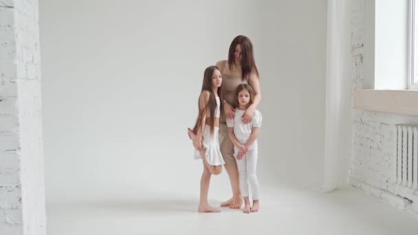 Mam en dochters poseren in een witte fotostudio voor een fotoshoot. backstage. — Stockvideo