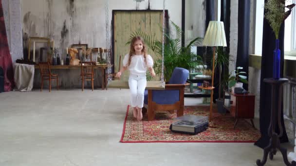 Petite fille monte sur une balançoire dans le grenier. séance photo dans un studio photo. — Video