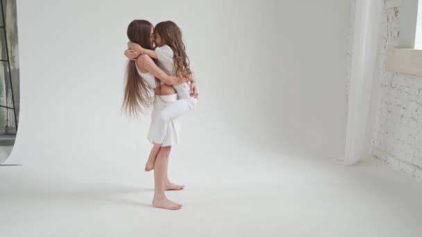 Kleine meisjes met lang haar in witte kleren spelen, verwennen, doen acrobatische trucs — Stockvideo