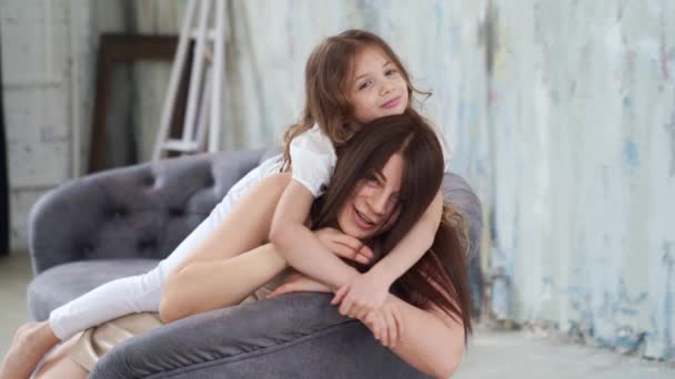 Mamma ligger på soffan och myser med sina döttrar. lycklig familj. backstage. — Stockvideo
