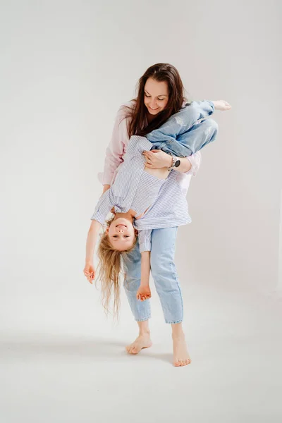 Schöne glückliche Familie beim Fotoshooting im weißen Fotostudio. Mutter und Tochter — Stockfoto