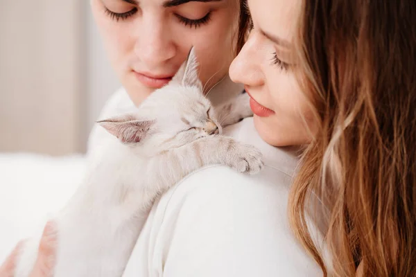 작고 흰 새끼 고양이를 안고 있는 아름다운 연인 부부. — 스톡 사진