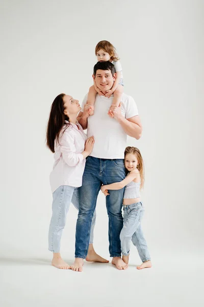 Hermosa familia feliz en una sesión de fotos en un estudio de fotos en blanco. tras bastidores. — Foto de Stock