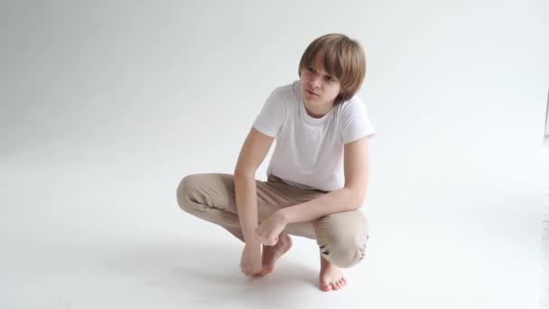 Teen boy in white T-shirt pose in a photo studio. — Stock Video