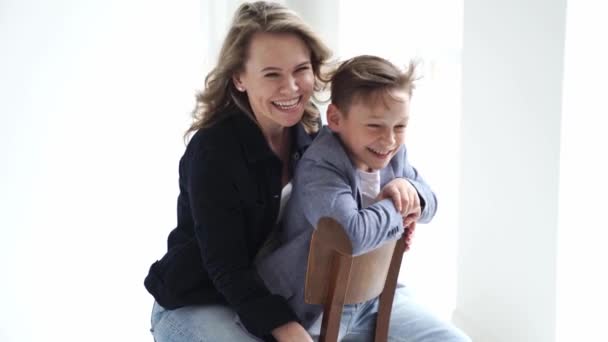 Uma mãe com filho em roupas azuis se divertindo e posa para uma sessão de fotos — Vídeo de Stock