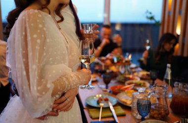 Gelin ve damat ellerinde şampanya kadehleri tutuyor..