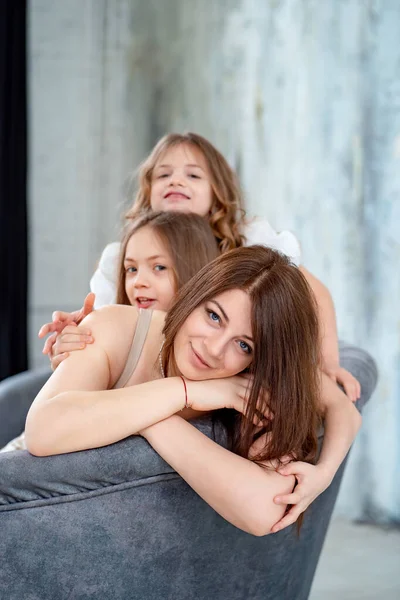 Mamá se acurruca con sus hijas. familia feliz. — Foto de Stock