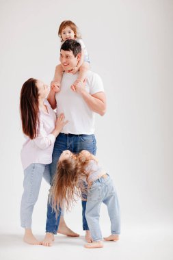 Beyaz bir fotoğraf stüdyosunda güzel, mutlu bir aile. veli-çocuk ilişkisi