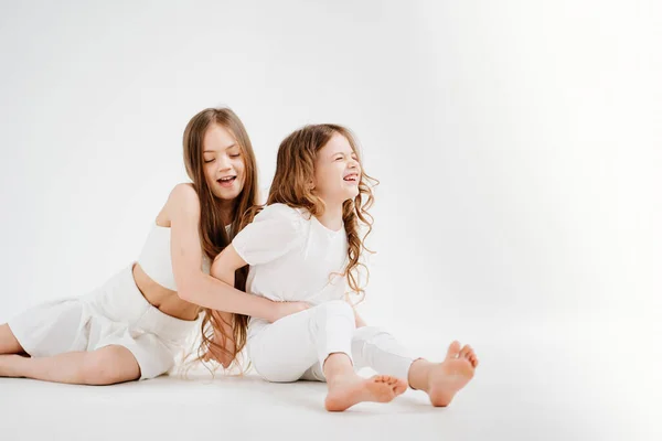 Dos niñas con el pelo largo en ropa blanca. amor entre hermanas. — Foto de Stock