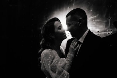 Gelin ve damat, karanlık bir koridorda zarif bir elbise içinde.