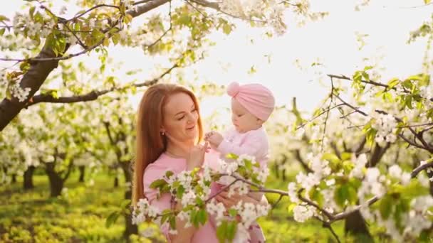 在开花的花园里抱着孩子的母亲。唇裂患儿外科治疗. — 图库视频影像
