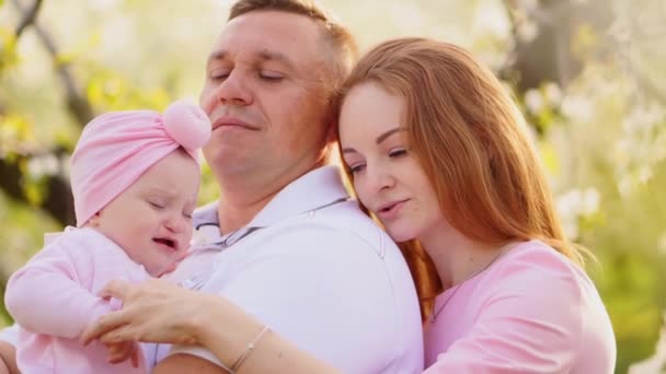 Familia con una hija pequeña. el bebé quiere dormir y chupa su dedo, llora — Vídeos de Stock