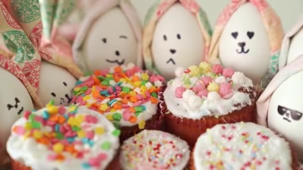 Cupcakes decorated with glaze and eggs painted like rabbits. revolves — Stock Video