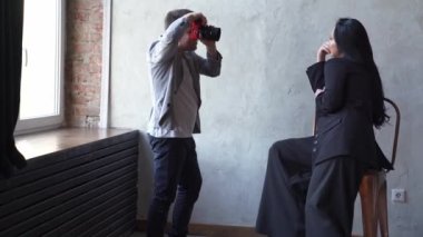 Güzel bir kadın yüksek bir sandalyede oturmuş fotoğrafçıya poz veriyor.. 